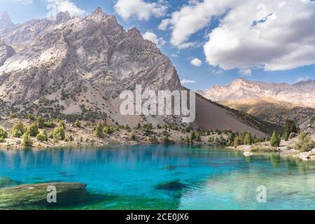 Die schöne Bergwanderstraße mit klarem blauen Himmel und Felsige Hügel und der Blick auf den Alaudin See in Fann Berge in Tadschikisch Stockfoto