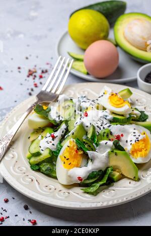 Spinatsalat mit Avocado, Gurke und Ei. Stockfoto