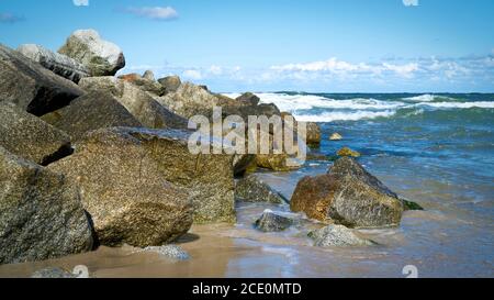 Felsbrocken als Wellenbrecher am Strand von Niechorze an der polnischen Ostseeküste Stockfoto