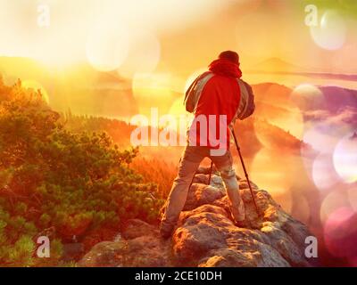 Filmeffekt. Glücklich Foto-Enthusiasten genießen Sie die Fotografie von Herbst Tagesanbruch in der Natur auf Felsen. Traumhafte Landschaft Stockfoto