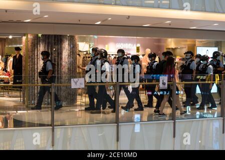 Hongkong, China. August 2020. Die Bereitschaftspolizei marschiert in der Moko Mall vor Plakaten, die von Protestierenden auf Glasbarrieren angebracht wurden, die sich auf die chinesische Redewendung "ein Hirsch ein Pferd nennen" beziehen (die populär wurde, nachdem Lam Cheuk-Ting und Ted Hui wegen "Ausschreitungen" bei den Yuen Long Zwischenfällen im Juli 2019 verhaftet wurden). Kredit: Marc R. Fernandes/Alamy Live Nachrichten Stockfoto