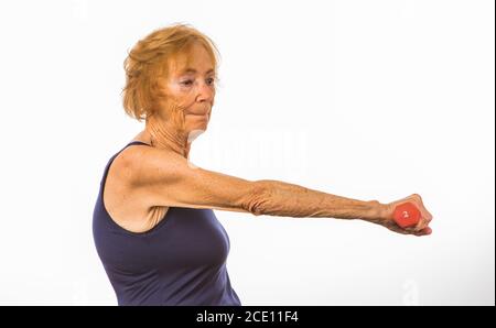 Ältere Frau, Die Sich Auf Das Heben Einer Kleinen Hantel Konzentriert Stockfoto