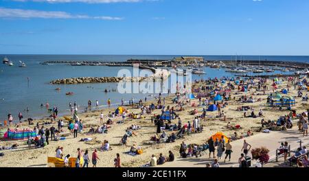 Lyme Regis, Dorset, Großbritannien. August 2020. UK Wetter: Strandgänger und Familien strömen am Bankfeiertag Sonntag zum vollen Strand im Badeort Lyme Regis, um die letzte heiße Sonne zu genießen. Kredit: Celia McMahon/Alamy Live Nachrichten Stockfoto