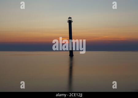 Leuchtturm Kiipsaare in Saaremaa, Estland. Ikonisches lokales Wahrzeichen - schräg verlassene Leuchtturm. Sonnenuntergang mit einem rot gefärbten Himmel. Stockfoto