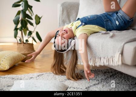 Teenager-Mädchen singen auf der Couch liegend Stockfoto