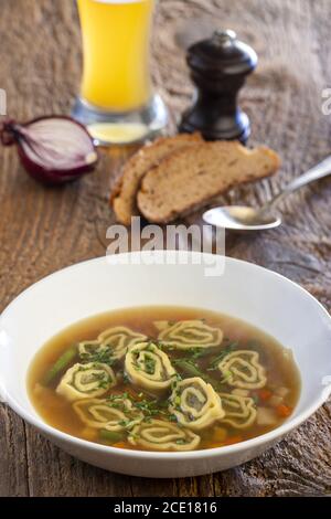 Bayerische Maultaschen Suppe auf Holz Stockfoto