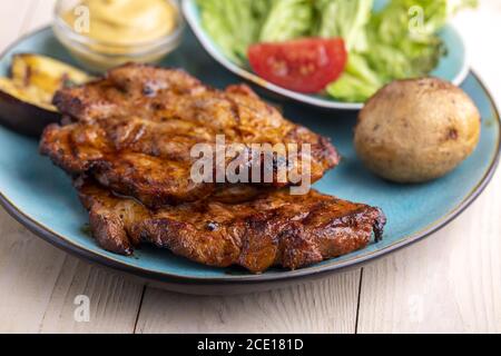 Gegrillte Schweinefleisch Steaks auf einem blauen Teller Stockfoto