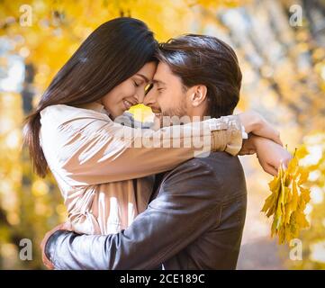 Nahaufnahme Porträt von liebevollen Paar Umarmung in goldenen Park Stockfoto