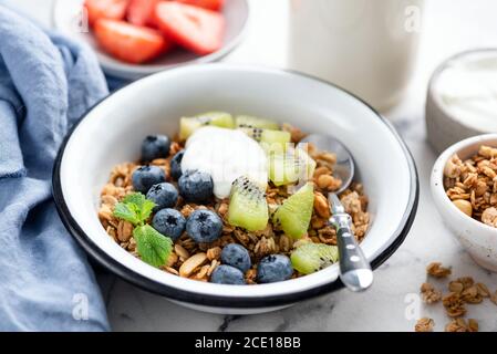 Müslischale mit Heidelbeere, Kiwi und griechischem Joghurt. Sauberes Essen, nachhaltiges Lebensmittelkonzept Stockfoto