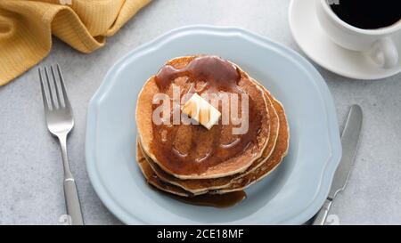 Pfannkuchen mit Butter und Ahornsirup auf dem Teller, Frühstück Stockfoto