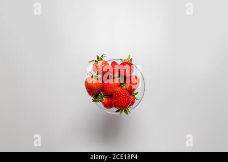 Schüssel mit frischen Erdbeeren auf weißem Hintergrund. Sommerkomposition Stockfoto