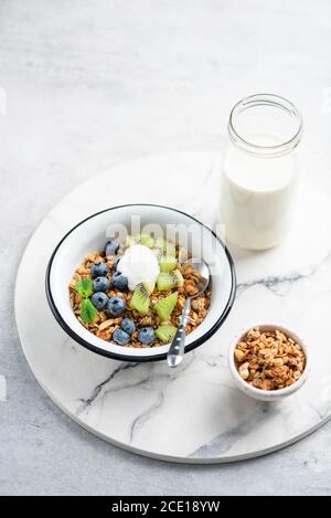 Schüssel Müsli mit Heidelbeeren, Kiwi und Joghurt. Gesundes Frühstück Essen, sauberes Essen Konzept Stockfoto