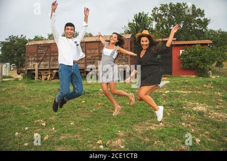 Drei Freunde springen, lachen und Spaß auf der Ranch haben. Ranch Konzept Fotografie Stockfoto