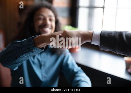 Nahaufnahme lächelnde afroamerikanische Mann Fäuste stoßen mit Freund Stockfoto