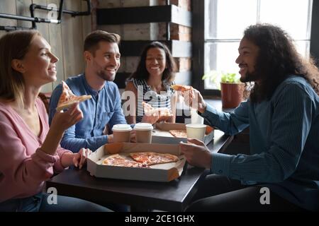 Überglücklich verschiedene Freunde genießen Pizza im Café zusammen Stockfoto