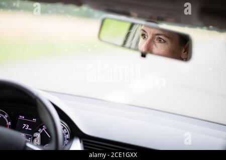 Hübsche Frau im mittleren Alter am Steuer von ihr Auto pendeln zur Arbeit Stockfoto