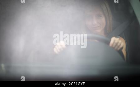 Hübsche Frau im mittleren Alter am Steuer von ihr Auto Stockfoto