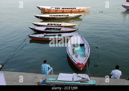 Lokale Menschen sitzen auf ganga Ghat & Boote Muster.Foto aufgenommen in der Nähe von munshi Ghat in varanasi indien. Stockfoto