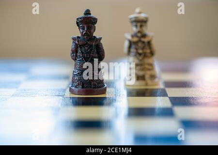 Nahaufnahme des schwarz-weißen Königsschachs, das auf einem Schachbrett sitzt. Schwarzer König versus weißer König. Stockfoto