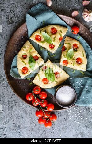 Italienisches Focaccia-Brot in Scheiben mit Tomaten und Basilikum Stockfoto