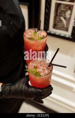 Cranberry Limonade auf der Fächerzone in den Händen eines Kellners auf dem Cob Stockfoto