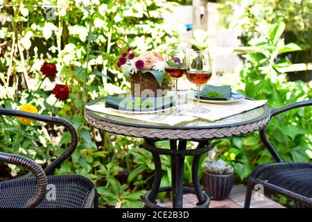 Abgeschiedenes Terrassencafe im wunderschön angelegten Garten Schöner Sommerabend zum Essen im Freien Stockfoto