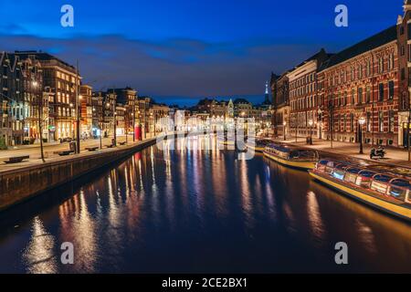 Amsterdam Stadtbild nach Sonnenuntergang, schöne alte europäische Stadt spiegelt sich in Amstel Fluss am Abend, Niederlande. Stockfoto