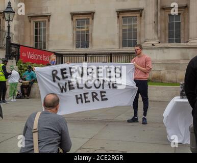 London, Großbritannien. August 2020. Zwei junge Demonstranten halten ein Banner mit dem Titel "Flüchtlinge willkommen hier" vor der National Gallery London auf dem Trafalgar Square, der während der Coronavirus-Pandemie ( covid-19) Besucher begrüßt. Quelle: Joe Kuis / Alamy News Stockfoto