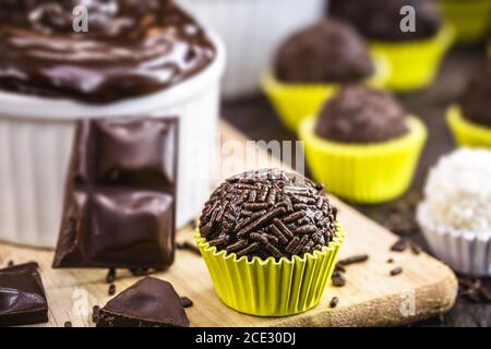 Brigadeiros oder Negrinhos, Süßigkeiten typisch für Kindergeburtstage in Brasilien, mit Schokolade um sie herum. Brasilianische Küche. Stockfoto