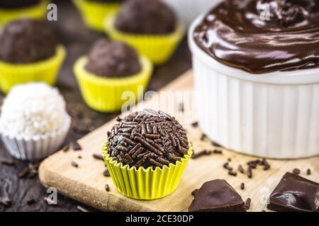 Brigadeiros oder Negrinhos, Süßigkeiten typisch für Kindergeburtstage in Brasilien, mit Schokolade um sie herum. Brasilianische Küche. Stockfoto