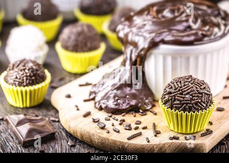 Brigadeiros oder Negrinhos, Süßigkeiten typisch für Kindergeburtstage in Brasilien, mit Schokolade um sie herum. Brasilianische Küche. Stockfoto