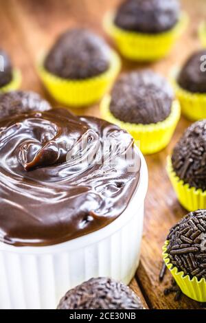 Brigadeiros oder Negrinhos, Süßigkeiten typisch für Kindergeburtstage in Brasilien, mit Schokolade um sie herum. Brasilianische Küche. Stockfoto