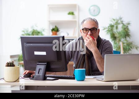 Leitender männlicher Mitarbeiter, der während einer Pandemie von zu Hause aus arbeitet Stockfoto