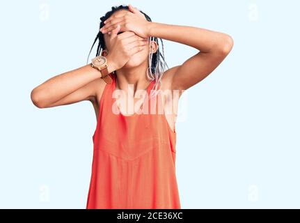 Cute african american Mädchen tragen lässige Kleidung, die Augen und Mund mit Händen, überrascht und schockiert. Versteckt Emotion Stockfoto