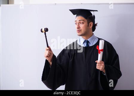 Junger männlicher Absolvent vor dem Vorstand Stockfoto