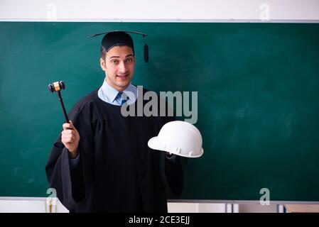 Junger männlicher Absolvent vor dem Vorstand Stockfoto