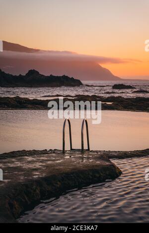 Wunderschöne natürliche Pools mit beruhigtem Wasser bei Sonnenuntergang. Entspannende, besinnliche Atmosphäre. Vertikal Stockfoto