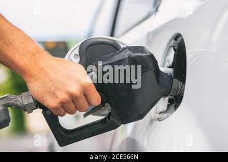 Auto, das Gas an der Gaspumpe pumpt. Nahaufnahme eines Menschen, der Benzin im Auto an der Tankstelle pumpt Stockfoto