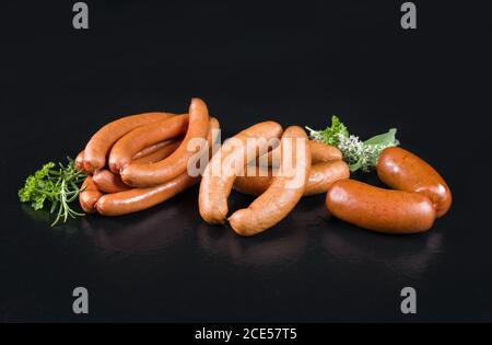 Traditionelle deutsche Würstchen zum Grillen, Braten und Kochen als Nahaufnahme auf einer schwarzen Tafel mit Kopierplatz Stockfoto