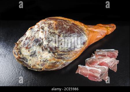 Traditionelle spanische jamon Iberico trocken gealterte Haunch eines duroc Schweinefleisch als Nahaufnahme auf schwarzem Hintergrund angeboten Stockfoto