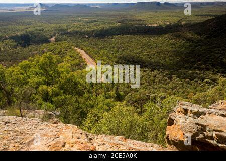 Landschaft von Hügeln und weiten Wäldern durchtrennt durch enge Straße Blick vom hohen Aussichtspunkt am südlichen Ende des Arcadia Valley Im Zentrum von Queensland, Australien Stockfoto