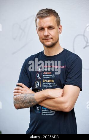 Hamburg, Deutschland. August 2020. Tobias Schlegl, Musiker, Moderator, Autor und Notarzt, trägt bei einer Fotosession im Schanzenviertel anlässlich der Vorstellung seines neuen Buches 'Schockraum' ein T-Shirt mit aufgedrucktem XABCDE-Schema. (To dpa ''Schockraum' von Tobi Schlegl- Roman über Rettungsdienste statt Therapie') Quelle: Georg Wendt/dpa/Alamy Live News Stockfoto