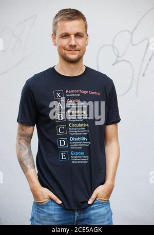 Hamburg, Deutschland. August 2020. Tobias Schlegl, Musiker, Moderator, Autor und Notarzt, trägt bei einer Fotosession im Schanzenviertel anlässlich der Vorstellung seines neuen Buches 'Schockraum' ein T-Shirt mit aufgedrucktem XABCDE-Schema. (To dpa ''Schockraum' von Tobi Schlegl- Roman über Rettungsdienste statt Therapie') Quelle: Georg Wendt/dpa/Alamy Live News Stockfoto