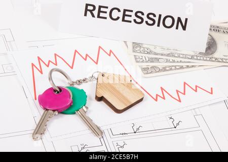 Schlüssel mit Home-Form, Währungen Dollar, Abwärtsgraphen und Inschrift Rezession auf elektrischen Bau Diagramme des Hauses. Immobilienkrise Stockfoto