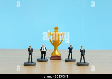 Miniatur Business-Konzept - Geschäftsmann Lineup Rang mit goldenen Trophäe In der Mitte Stockfoto