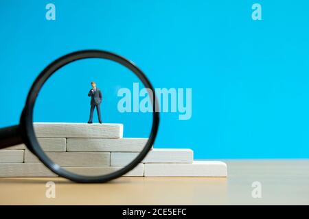 Business-Strategie konzeptionelles Foto - Miniatur des Geschäftsmannes steht auf Ein Podium Stockfoto