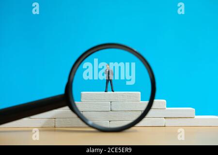 Business-Strategie konzeptionelles Foto - Miniatur des Geschäftsmannes steht auf Ein Podium Stockfoto