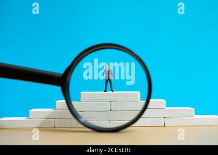 Business-Strategie konzeptionelles Foto - Miniatur des Geschäftsmannes steht auf Ein Podium Stockfoto