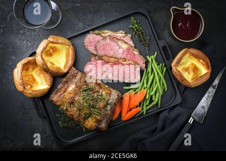 Traditionelle Commonwealth Sonntag Braten mit Aufschnitt Aufschnitt Roastbeef Mit Gemüse und Yorkshire Pudding als Draufsicht auf einem Mod Stockfoto