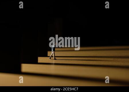 Business-Konzeptfoto – Miniatur des Geschäftsmannes aus Bürogebäude im Morgengrauen – Kommen nach Hause spät Konzept Stockfoto